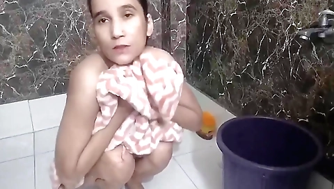Indian girl fills her hole with water in the bathroom
