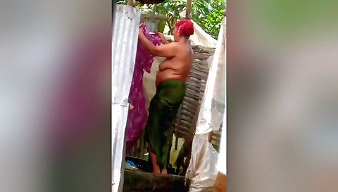 Indian mature woman naked in open field and using sponge